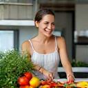 Femme souriante préparant des légumes frais